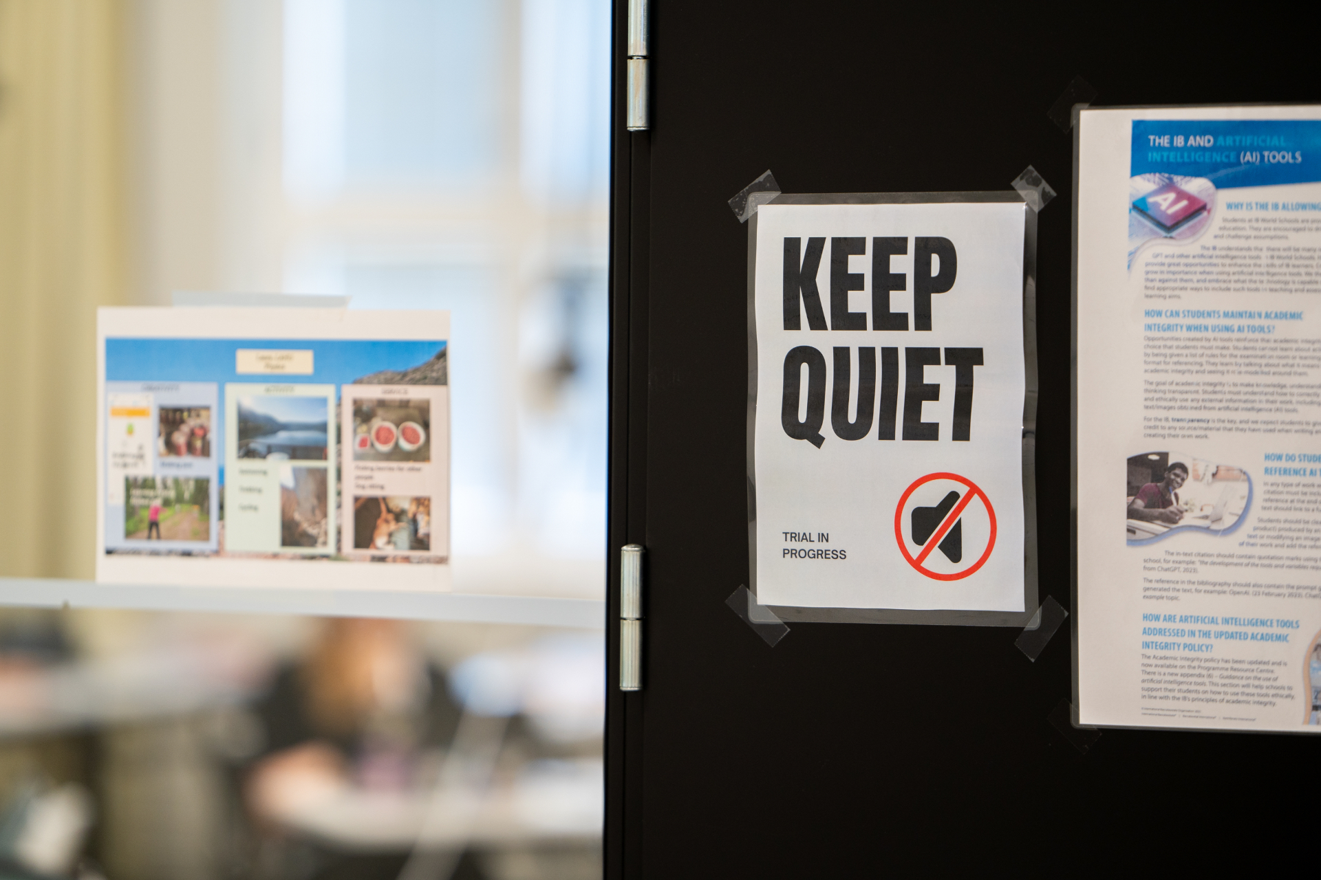 A 'Keep quiet — trial in progress' sign taped to a courtroom door at HYMT 2024
