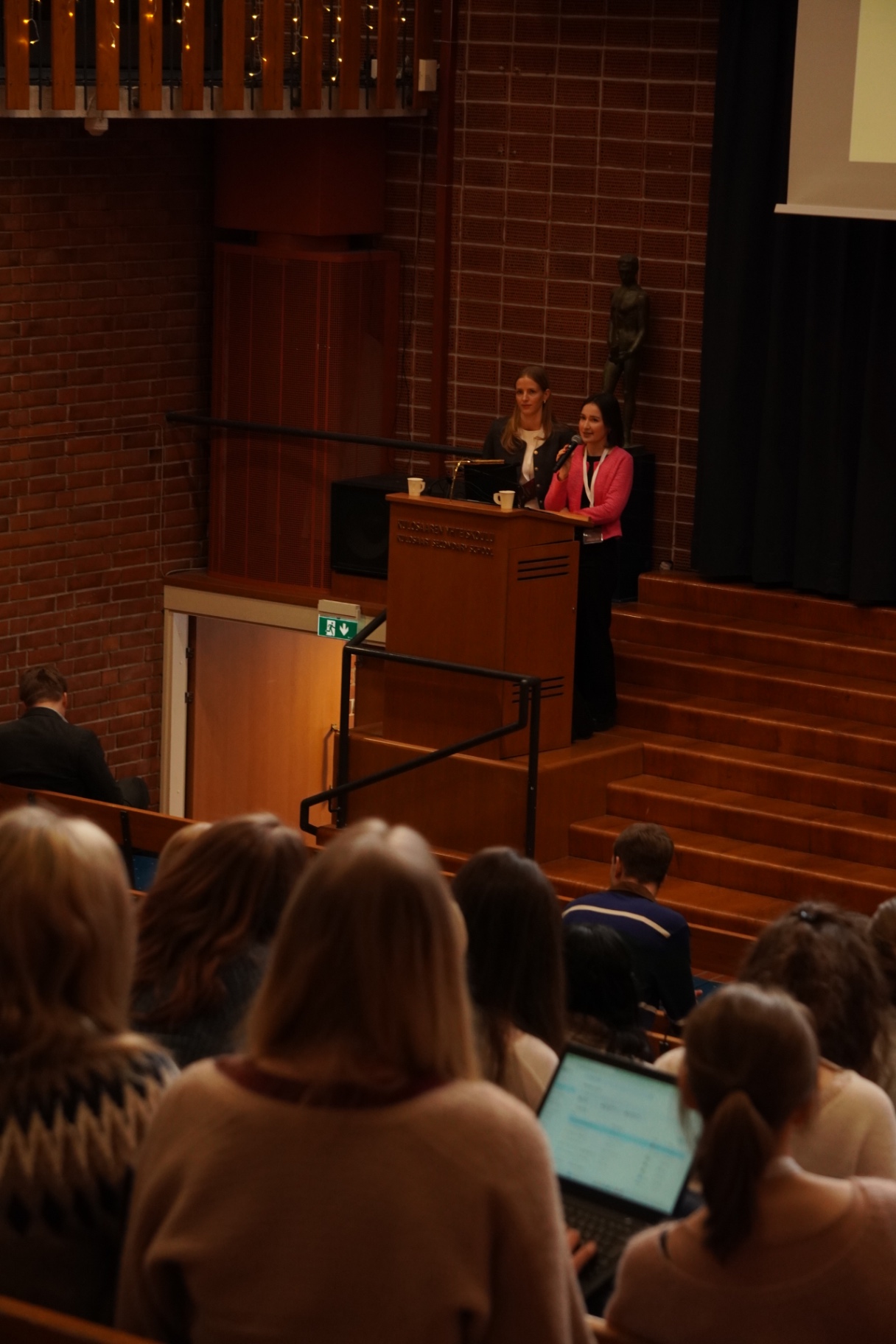 Organisers welcoming delegates from the lectern at HYMT 2026